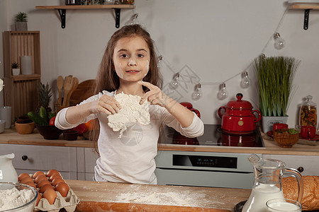 穿白上衣的漂亮小女孩 在厨房烤面包赚了点面粉呢 笑声厨师滚动家庭牛奶菜单乐趣食谱乡村桌子女孩图片