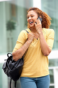 在城市里 年轻妇女走路和用手机说话;在城市里图片