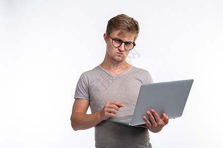 研究 教育和人的概念     一个严肃的英俊年轻男子 看白色背景的网上书套装极客下巴商业自由职业者工人电脑经理维修思维图片