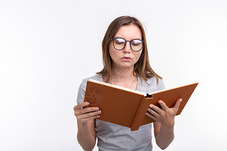 人与教育概念有吸引力的妇女以白人背景阅读一本书的白种背景女士女孩女性黑发文件夹头发成人男性笔记眼镜图片