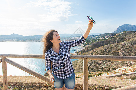 旅行 旅游和度假概念     快乐的年轻妇女在海边自拍图片