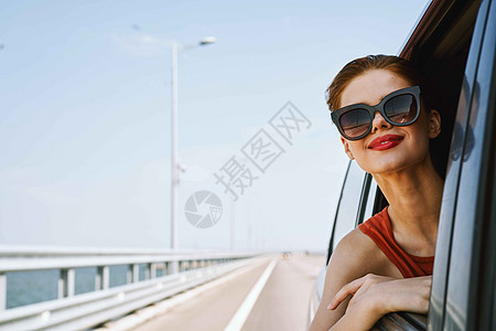 一个女人开车在路上 望着窗外的一辆车晴天驾驶司机女孩夫妻汽车乐趣假期太阳朋友们图片
