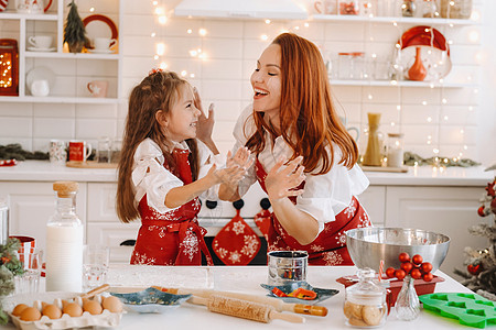新年厨房的妈妈和女儿 一起为圣诞饼干准备点钱吃吧帮助女孩助手食物面团父母围裙房子价值观家庭图片