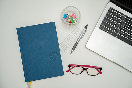 办公桌上的办公用品 包括键盘 眼镜和用于远程工作的咖啡杯 用于学习的各种学校公用设施 包括热饮和眼镜互联网职业材料铅笔木头计算机图片