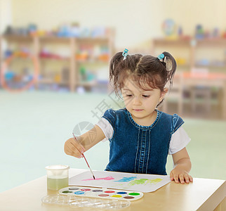 小姑娘在桌子上涂着水彩画家具学校房间孩子们卧室教育创造力玩具幼儿园刷子图片