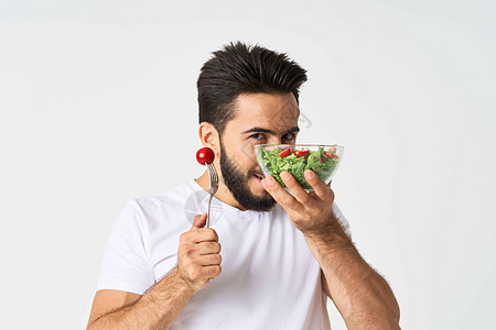 一个穿着白色T恤的男人 盘子里有沙拉和零食健康食品营养成人生态水平黄瓜胡子玻璃食物相机饮食图片
