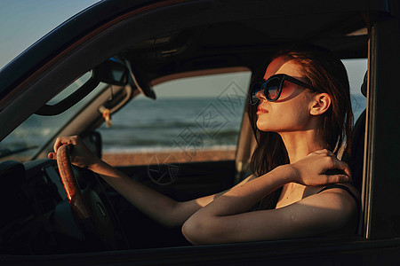 戴着太阳眼镜的开心女人 驾车出行旅行太阳镜眼镜魅力交通商业太阳车辆女孩敞篷车奢华图片