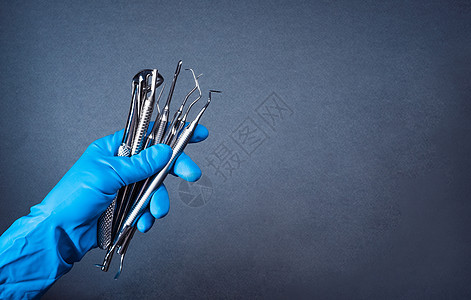 持有金属牙科设备的蓝手套内手戴蓝色手套保健牙齿治疗考试外科诊所医院药品医生手术图片