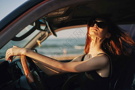 穿着太阳眼镜的漂亮女人 驾车出行眼镜女性魅力汽车女孩交通商业奢华微笑阳光图片