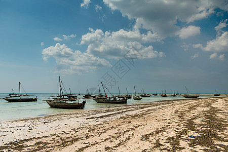 桑给巴尔海岸上有渔船的风景海浪钓鱼渔夫天空假期旅行天堂蓝色海滩地平线图片