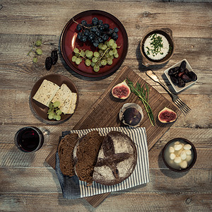 木本底带奶酪和葡萄的面包水果枣果餐巾纸桌子黑色酒杯木板产品灰色乡村图片