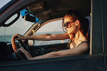 以时装旅行方式驾驶汽车的妇女司机商业车轮太阳镜窗户女性奢华微笑太阳女孩图片