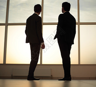 两位商务人士从商业中心的窗口看城市 在市中心一望一望套装男性挑战管理人员商务窗户办公室伙伴男人工作图片