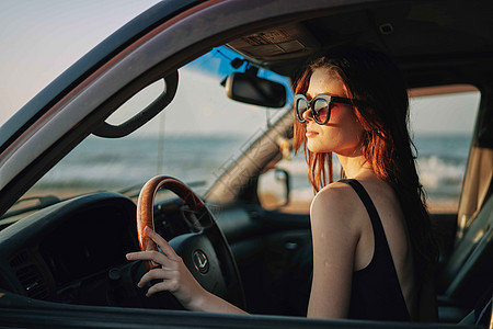 穿着太阳眼镜的漂亮女人 驾车出行汽车太阳镜车轮眼镜车辆窗户敞篷车魅力头发交通图片