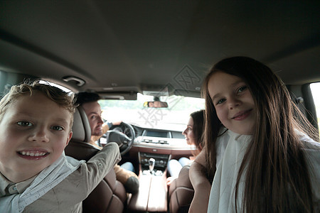 儿童坐在汽车后座的车后座上乐趣假期女士窗户男人母亲孩子晴天微笑女性图片