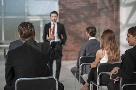 工作人员在一次会议上举手回答一个问题 并在一次会议上商务领导者投票玻璃老板商业团队成人合伙职业图片