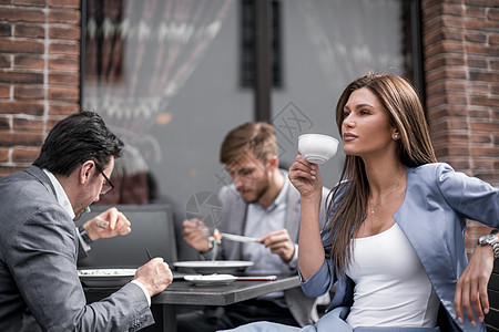 有咖啡杯的女商务人士 坐在一个舒适咖啡厅的桌子上女性办公室人士成人工作友谊餐厅团体食物商务图片