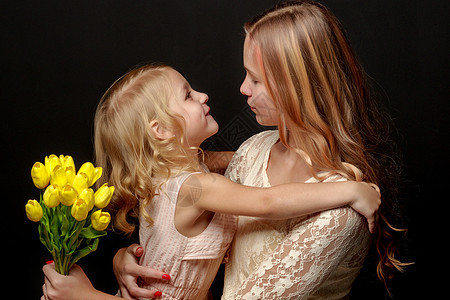 两个带着鲜花的小女孩青年花园花朵头发闺蜜幸福喜悦拥抱乐趣孩子图片