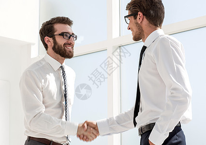 快乐的同事们彼此握手相握成就会议微笑伙伴经理商业手势交易合作衬衫图片
