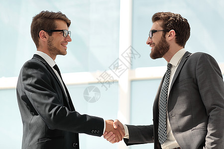两个商务人士握手握手窗户办公室同事工人客户经理项目合伙流程工作背景
