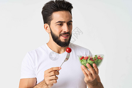 穿着白色T恤的快乐男人 一盘配沙拉蔬菜饮食的餐盘黄瓜烹饪厨师食物生活营养生态水平玻璃绿色背景图片