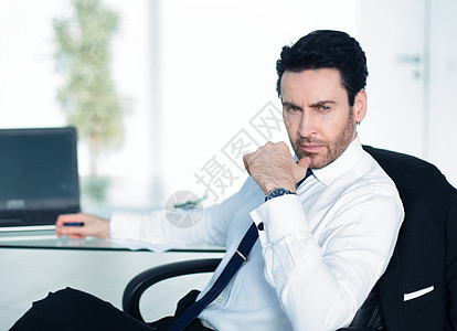 坐在办公桌前深思熟虑的商务人士微笑人士办公室商务商业电脑职场经理成人工作图片