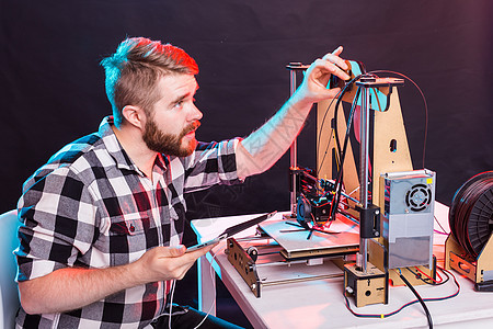 年轻男性设计师工程师在实验室使用 3D 打印机并研究产品原型 技术和创新概念工具研究员科学教育笔记本印刷电脑软件工程电气图片