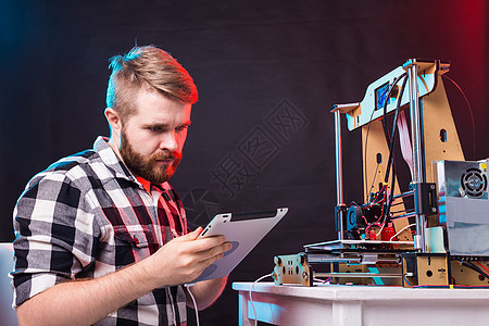 年轻男性设计师工程师在实验室使用 3D 打印机并研究产品原型 技术和创新概念电子产品胡须学习发明电气打印电脑科学软件印刷图片