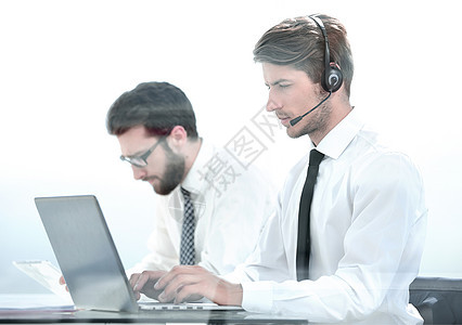 头耳机管理员使用笔记本电脑与客户合作互联网经理男人电话中心团队银行业商业玻璃服务图片