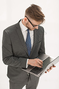 商务人士测试一台新的笔记本电脑工人眼镜管理人员专注人士办公室成功领带男人工作图片