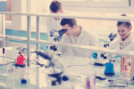 从事研究的年轻医科学生群体科学家大学技术员化学家考试显微镜管道医生女性实验图片