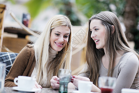 喝咖啡的可爱笑笑着的女人快乐闲暇黑发微笑会议杯子讲话朋友们头发咖啡图片