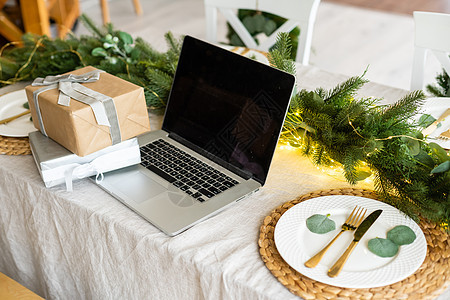带有礼品盒和圣诞节灯光背景的手提笔记本电脑商业假期监视器购物键盘房间礼物庆典展示盒子图片