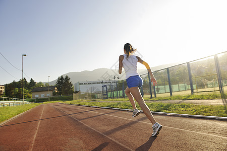 妇女清晨慢跑福利行动成人训练车道赛马场日出跑步太阳娱乐图片