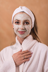 施用面罩的斯帕妇女皮肤沙龙肤色女性奢华毛巾成人黏土面具润肤图片