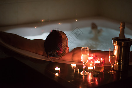 男人在按摩浴缸里放松温泉假期休息蜡烛男性微笑气泡眼镜身体水疗图片
