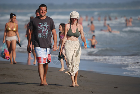 幸福的情侣在海滩上散步异性日落女士拥抱地平线游泳衣嘴唇海洋摄影环境图片