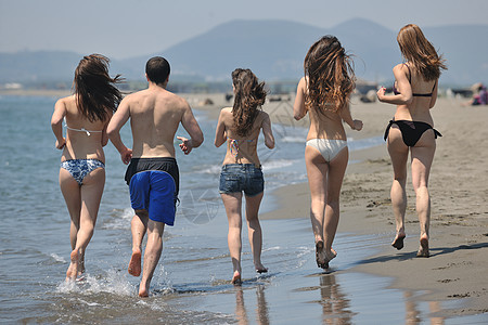 快乐的人群有乐趣 在海滩上奔跑季节跑步微笑团体活力朋友们运动假期团队喜悦图片