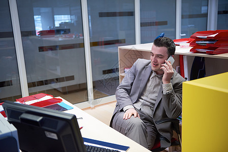 在办公室里通过电话说话的商务人士电脑桌子商务公司笔记本工作人士商业套装男人图片