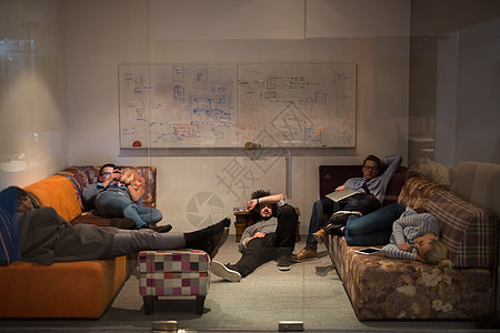 在创意启动办公室睡在沙发上的软件开发商桌子管理人员男性职场睡眠电脑商务职业男人人士图片
