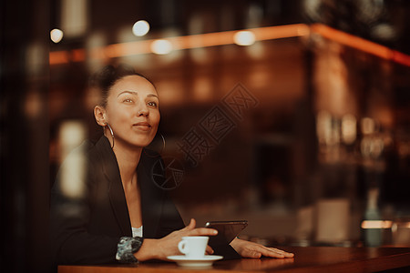 一个拉蒂诺女人 坐在咖啡厅休息休息安装自由职业者咖啡馆通讯女性技术网络互联网设备博主图片