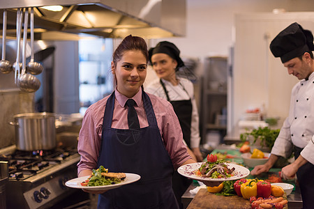 年轻女服务员 展示美味饮食的菜盘工作女士女性商业食物厨师盘子菜肴美食职业图片