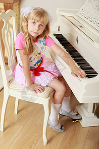 女孩弹钢琴白色童年音乐裙子闲暇孩子教育房间黑色婴儿图片