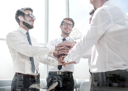 商业界的同事将双手折叠在一起手势团体多样性商务成就会议桌子合伙友谊社区图片