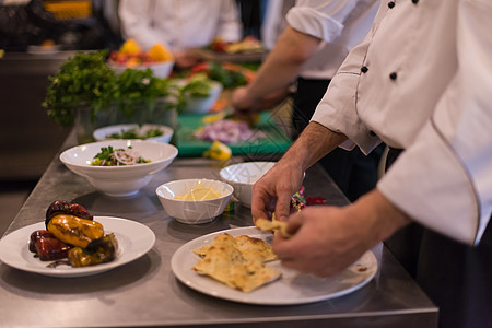 团队厨师和准备饭食的厨师餐饮食物蔬菜盘子服务厨房职员酒店同事商业图片