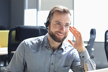 微笑友好英俊的年轻男性呼叫中心接线员操作员耳机商业快乐工作帮助顾问办公室成人推销图片