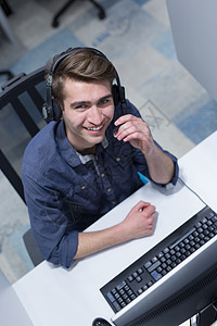 男性呼叫中心操作员在做工作时的顶端视图男人助手顾问推销商业电话邮件办公室顾客麦克风图片