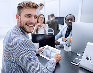 坐在办公服务台的笑着微笑的商务人士同事生意管理人员笔记本公司互联网男人电脑职业商务图片