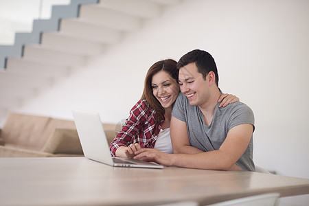 幸福的年轻夫妇在线购买快乐房子沙发购物女性妻子信用女士互联网男朋友图片