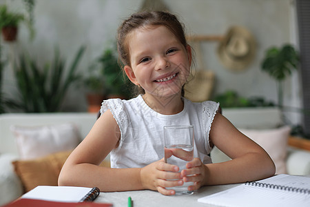 快乐的小女孩把晶体矿泉水装在玻璃里 小孩子建议每天用干净的水图片